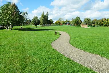a path stretching out over a field in a park