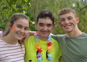 three students in casual smiling and face paint smiling